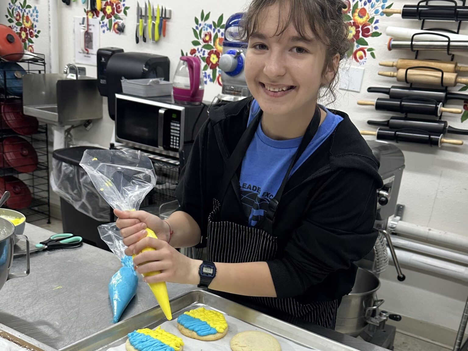 Viktoriia decorating her Kindness Cookies at the bakery.
